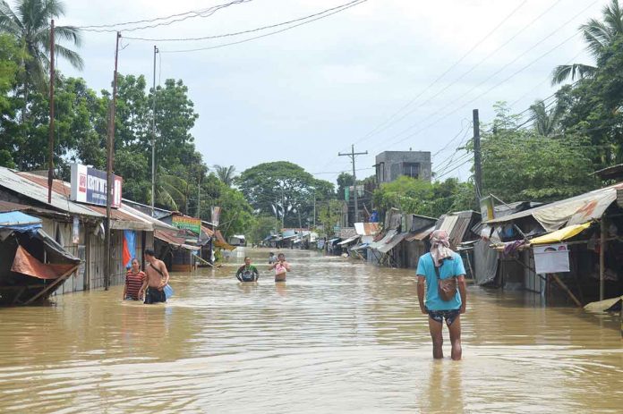 WATER EVERYWHERE. Residents of Barangay Jalaud Norte, Zarraga, Iloilo wade through waist-high floodwaters. The town was pounded by heavy rains from April 10 to 12. On Wednesday morning, April 13, the floodwaters have yet to recede. PN PHOTO