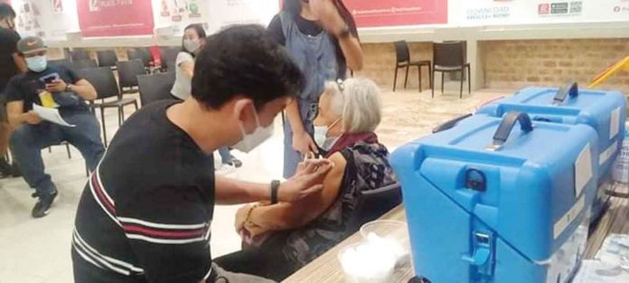 A senior citizen is assisted by relatives after getting her shot of the vaccine against coronavirus disease at a mall in Pavia, Iloilo. The provincial government of Iloilo has taken its vaccination drive to the malls to increase the province’s inoculation rate, especially among the elderly. ILOILO PROVINCIAL HEALTH OFFICE PHOTO