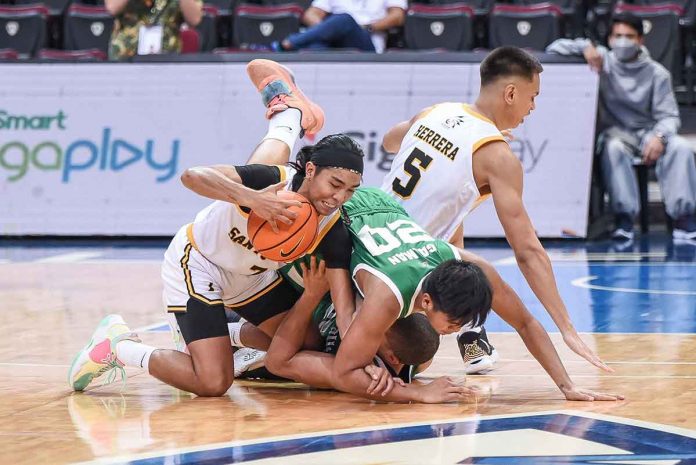 University of Santo Tomas Growling Tigers’ Joshua Fontanilla got away with the ball in a mad scramble for the looseball with De La Salle University Green Archers' Emman Galman and Mike Philipps. UAAP MEDIA BUREAU