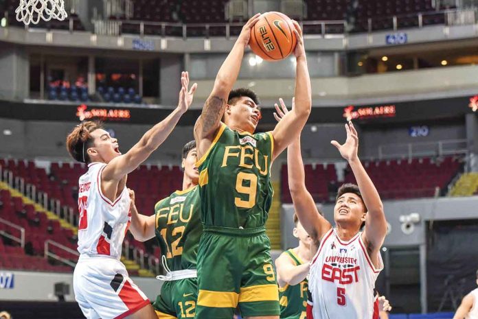 Ilonggo John Bryan Sajonia of Far Eastern University Tamaraws grabs the rebound while being surrounded by defenders. UAAP MEDIA BUREAU