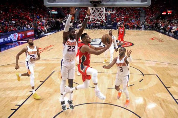 New Orleans Pelicans guard CJ McCollum (3) scores on a reverse layup as Phoenix Suns center Deandre Ayton (22) defends. AP PHOTO/MICHAEL DEMOCKER