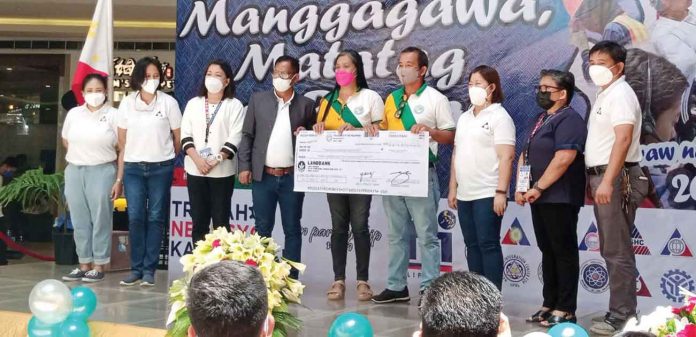 Members of the Batad Multi-Purpose Cooperative headed by Cesar Lariza receives a ceremonial check from the Department of Labor and Employment - Region 6 director Atty. Sixto Rodriguez. GLENDA TAYONA/PN