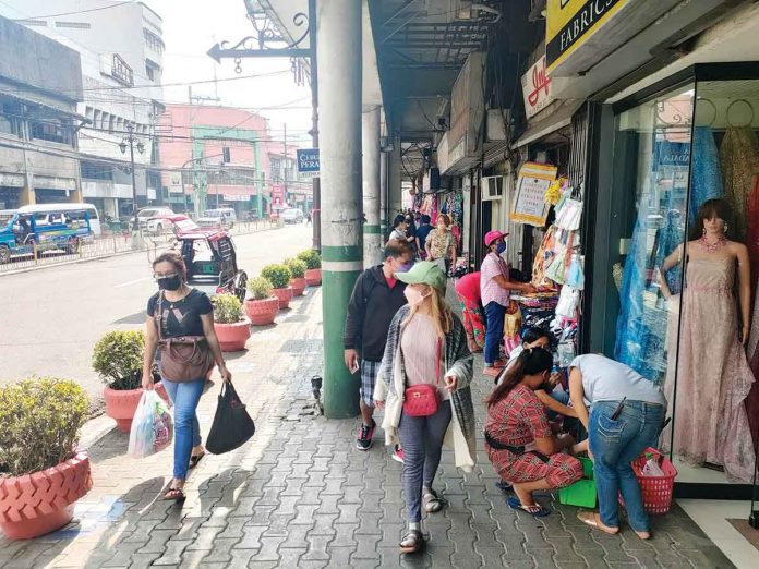 BACK IN BUSINESS BUT NOT QUITE. Since Iloilo City relaxed its pandemic restrictions, businesses along its Calle Real or JM Basa Street in the metro’s old business district have again attracted shoppers. The volume of people, however, is not yet back to pre-pandemic levels. An unrealistic wage increase could derail the recovery of businesses, a group of businessmen warns. PN PHOTO