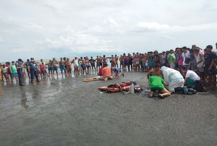 Rescuers try to revive two drowning victims along the shores of Barangay Sampinit, Bago City, Negros Occidental.