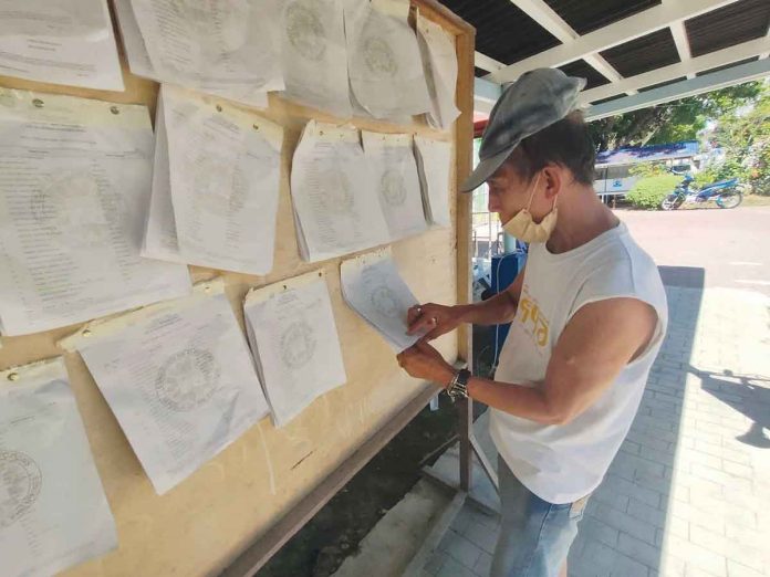 A registered voter in Iloilo City checks if his name is on the official list of voters. PN PHOTO