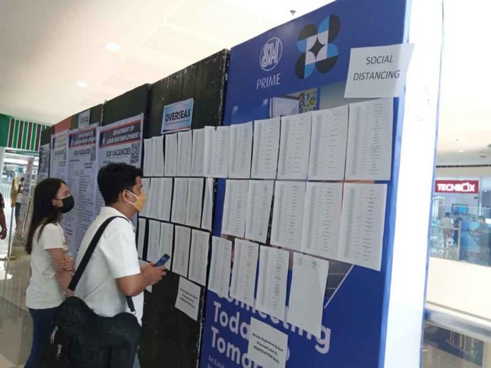 Job hunters check lists of vacancies during the Labor Day jobs fair on May 1 at a mall in Mandurriao, Iloilo City. The Department of Trade and Industry underscores to job hunters and even to those already employed the importance of “upskilling”. This will open better job opportunities. PHOTO BY GLENDA SOLOGASTOA/PN