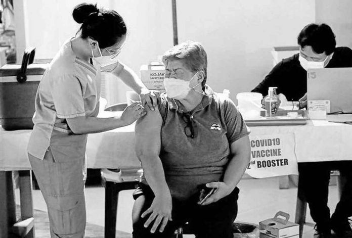 An elderly woman gets her second vaccine booster, but others may not even need it at all. RICHARD A. REYES ©PHILIPPINE DAILY INQUIRER 2022