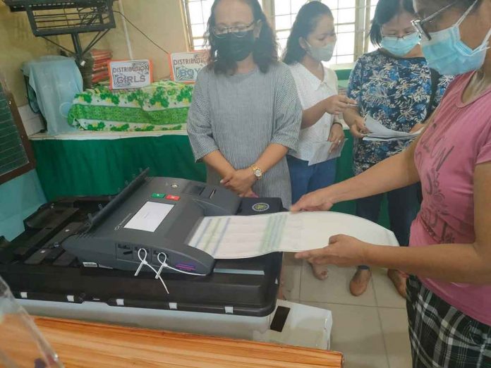 VOTE TESTING. A voter tests feeding a ballot into this vote-counting machine (VCM) during the final testing and sealing of the machines in Iloilo City on Saturday, May 7, in preparation for the elections today, May 9, 2022. A total of 8,570 VCMs will be used in 8,570 clustered precincts across Region 6 today, according to the Commission on Elections. PN PHOTO