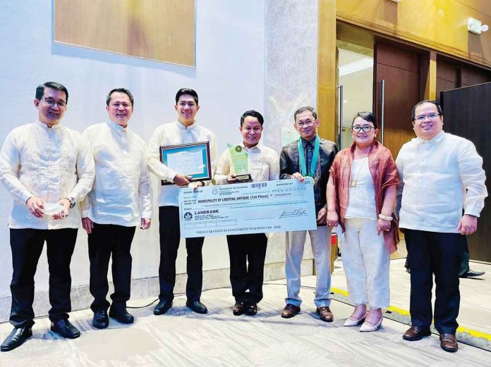 Team Libertad headed by Mayor Mary Jean Te (second from right) receives a plaque of recognition and symbolic check prize for Libertad, Antique’s being declared as “Best Implementor of Population and Development (PopDev) Integration” in the nationwide 2022 Kaunlarang Pantao Award of the Commission on Population and Development. PHOTO FROM MAYOR BEBOT NICOPIOR-TE FACEBOOK PAGE