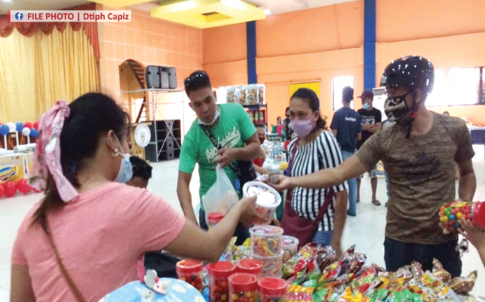 People buy from a retailer participating in the Department of Trade and Industry’s “Diskwento Caravan Balik Eskwela” in Capiz in this undated photo. DTI-CAPIZ PHOTO