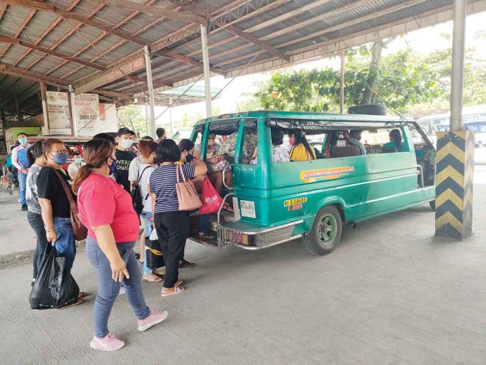 Passengers from Iloilo province board an Iloilo City-bound jeepney at the transport terminal in Barangay Ungka, Jaro district. The city’s Local Public Transport Route Plan prohibits provincial jeepneys from entering the city. ARNEL JOHN PALCULLO/PN