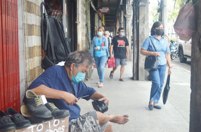 HONEST LABOR. A shoe repairman works on the sidewalk of Ledesma Street, Iloilo City undistracted by passersby. He has to fix this shoe right. The more pairs of shoes he repairs in a day, the more income he will have. PN PHOTO