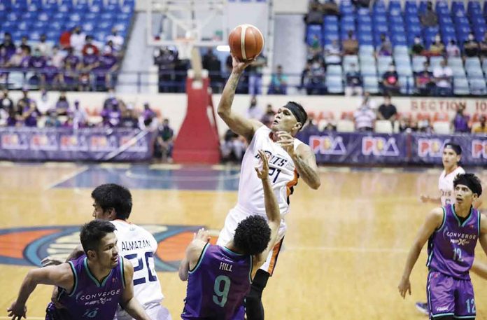 Negrense Reynel Hugnatan of Meralco Bolts attempts a one-hander while being defended by Converge FiberXers’ Tyrus Hill. PBA MEDIA BUREAU