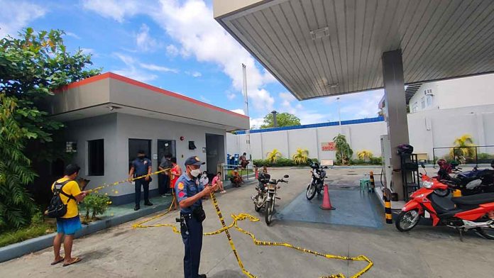 A policeman is securing this robbed gasoline station in Jaro district with a yellow tape. The area is considered a crime scene. PHOTOS FROM ARNEL JOHN PALCULLO/PN