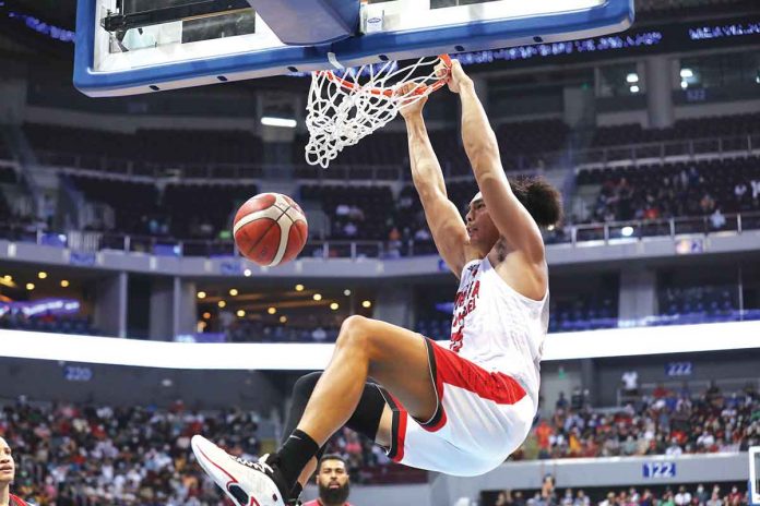 Barangay Ginebra San Miguel Kings’ Japeth Aguilar hangs into the ring after a two-handed slam dunk. PBA MEDIA BUREAU