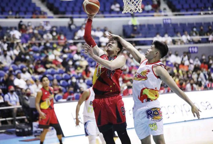 San Miguel Beermen’s John Rodney Brondial manages to convert a basket despite being hacked in the head by Rain or Shine Elasto Painters’ Leonard Santillan. PBA MEDIA BUREAU