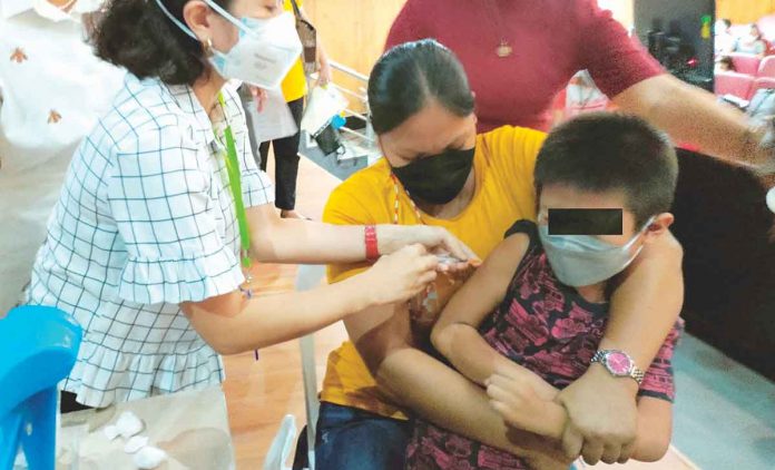 A boy gets a shot of the vaccine against coronavirus disease while being restrained by his mother, in this photo taken during the kickoff of the Iloilo provincial government’s vaccination campaign for young children early this year. PN PHOTO