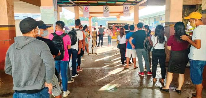 Passengers at the transport terminal in Barangay Tabak, Jaro district form two long lines while waiting for jeepneys that would take them to Iloilo City. They can no longer enter the city onboard provincial jeepneys. ARNEL JOHN PALCULLO/PN