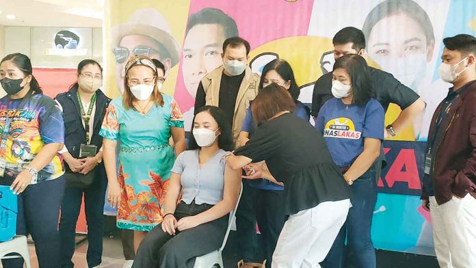 A young woman avails herself of COVID-19 shots during the launching of the “PinasLakas” vaccination campaign at Robinsons Place Jaro in Iloilo City on July 26, 2022. ARNEL JOHN PALCULLO/PN