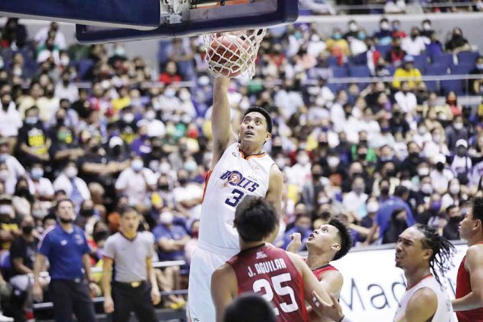 Meralco Bolts center Kyle Pascual scores on an uncontested dunk as Barangay Ginebra San Miguel Kings’ Japeth Aguilar and Earl Scottie Thompson look on. PBA MEDIA BUREAU