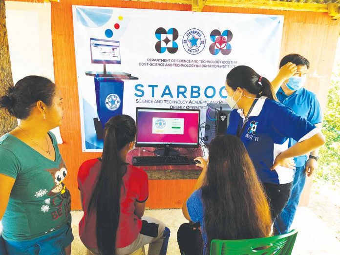 Participants of the hands-on demonstration of the Science and Technology Academic and Research-Based Openly Operated KioskS (STARBOOKS) observe how to operate the unit for community members to easily access scientific educational material. One unit of STARBOOKS was deployed to Barangay Cabugao, Ibajay Aklan for easier offline education.