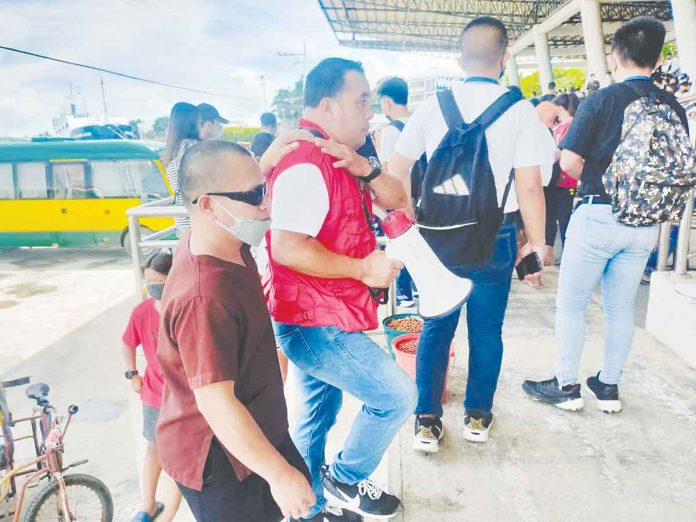 A Department of Social Welfare and Development Region 6 personnel helps a blind get settled at the Iloilo City Freedom Grandstand during the second payout for educational assistance to students. DSWD WESTERN VISAYAS FB PAGE