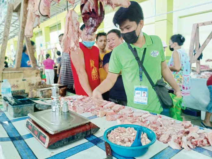 A personnel of the Department of Trade and Industry checks a weigh scale at the public market of Patnongon, Antique. PIA PHOTO