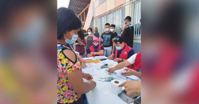 Margielyn Sobredo of Pototan, Iloilo receives the educational cash assistance for her two children grades 7 and 9 at the Iloilo Sports Complex on August 20, 2022. DSWD-6