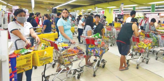 Under Republic Act No. 7581 or the Price Act, the government must make sure basic necessities and prime commodities are available at reasonable prices, especially during emergency situations, such as the ongoing coronavirus disease pandemic. Photo shows shoppers queuing at a grocery store in Iloilo City. A consumers’ group seeks a freeze in the prices of basic goods and prime commodities. PN PHOTO