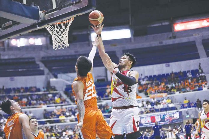 San Miguel Beermen’s June Mar Fajardo shoots from close range against the defense of Meralco Bolts’ Raymond Almazan. PBA MEDIA BUREAU