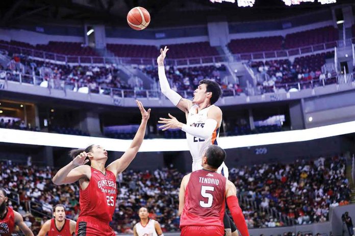 Meralco Bolts’ Raymond Almazan attempts a close hit against the defense of Barangay Ginebra San Miguel Kings’ Japeth Aguilar. PBA Media BUREAU