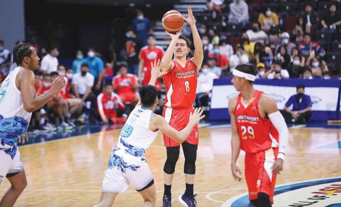 NorthPort Batang Pier’s Robert Bolick Jr. hoists a triple against the defense of Phoenix Super LPG Fuel Masters’ Tyler Tio. PBA PHOTO