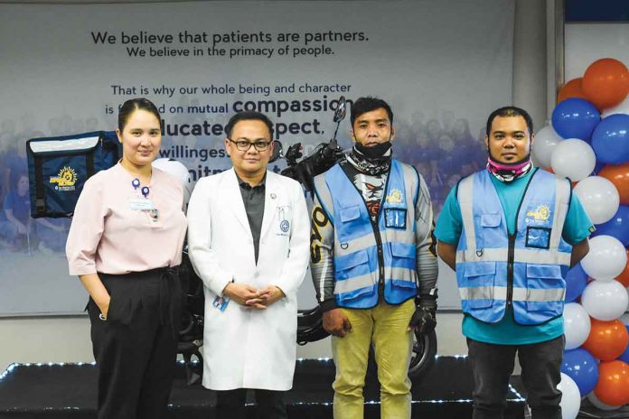 The Medical City Iloilo (TMC Iloilo) Director of Nursing Aliver Vagilidad and TMC Iloilo CEO Dr. Felix Ray Villa together with TMC Iloilo Express Delivery drivers.