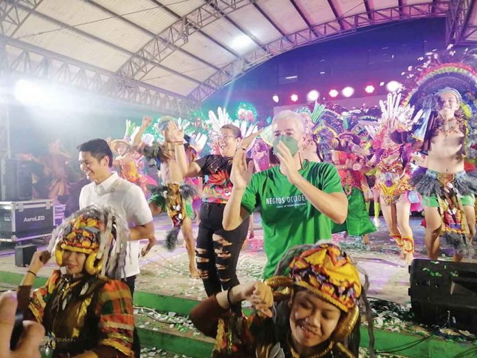 Negros Occidental governor Eugenio Jose Lacson, together with La Castellana mayor Rhumylla Nicor-Mangilimutan and Victorias City mayor Javier Miguel Benitez, join the merrymaking during the MassKara sa Panaad opening event on October 10. (Dominique Gabriel G. Bañaga photo)