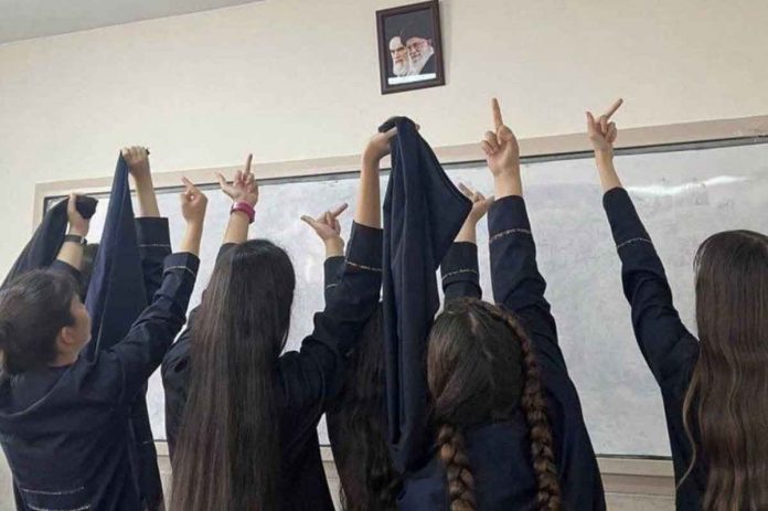 Protesting Iranian school girls raise their middle fingers – an obscene gesture – at the portraits of Ayatollah Khamenei and the founder of the Islamic Republic, Ayatollah Ruhollah Khomeini. BBC