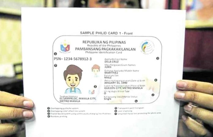 PAPER ID. A congressional worker shows a sample of the PhilSys ID presented to the House of Representatives when the Philippine Statistics Authority was seeking funding. INQUIRER FILE PHOTO