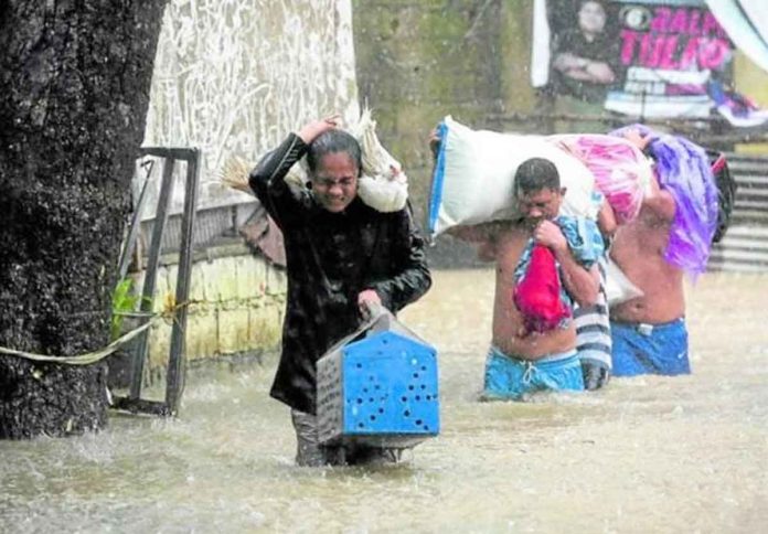 MUST SAVE EVERYONE. Residents evacuate with their livestock and a few belongings in Barangay Bagong Silangan, Quezon City, one of the low-lying areas where floodwaters rose quickly on Saturday morning as “Paeng” drew nearer to Metro Manila. PHOTO BY LYN RILLON / PHILIPPINE DAILY INQUIRER