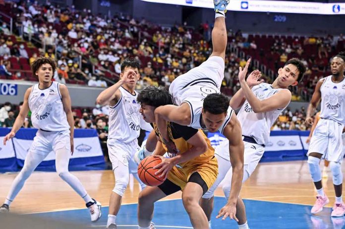 Adamson University Falcons’ Joshua Yerro loses his balance as he tries to stop University of Santo Tomas Growling Tigers’ Kenji Duremdes from scoring inside. UAAP PHOTO