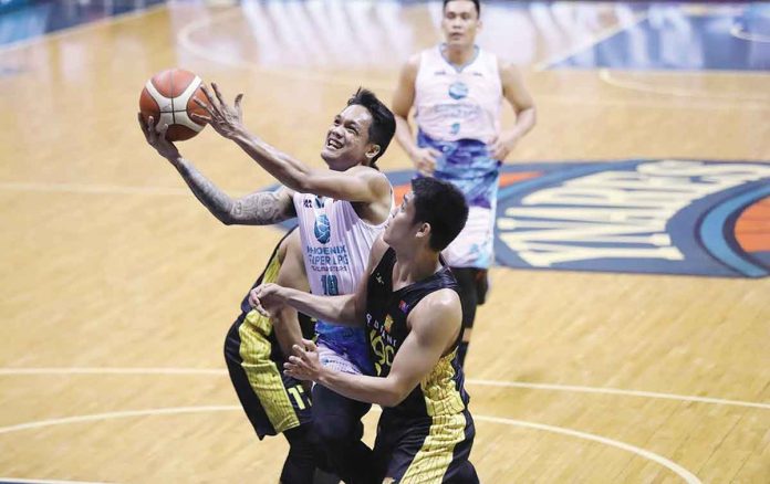 Phoenix Super LPG Fuel Masters’ Encho Serrano charges to the defense of TNT Tropang Giga’s Calvin Oftana for a layup. PBA MEDIA BUREAU