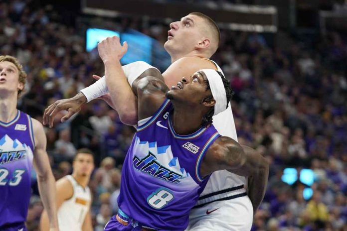 Utah Jazz’s Jarred Vanderbilt locks arms with Denver Nuggets’ Nikola Jokić during a rebound battle. AP