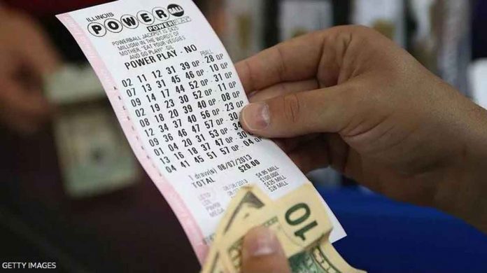 A woman holds her Powerball lotto ticket. GETTY IMAGES