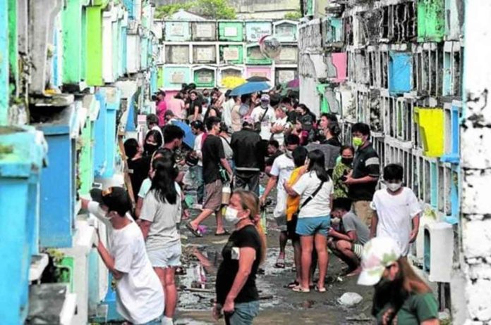 MIXED CROWD. People with mask and no mask pay respects to their departed loved ones in Valenzuela Public Cemetery, Valenzuela City, on All Saints’ Day. PHOTO BY GRIG C. MONTEGRANDE / PHILIPPINE DAILY INQUIRER