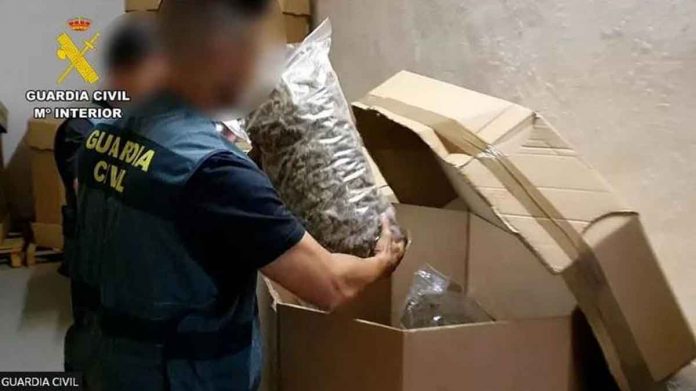 A police officer moves a bag of cannabis following a raid. The stored cannabis was equivalent to 1.1 million plants. GUARDIA CIVIL