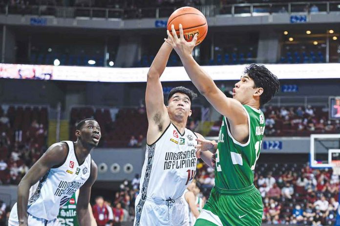 De La Salle University Green Archers’ Earl Abadam scoops for a layup as University of the Philippines Fighting Maroons’ Richi Calimag attempts for a block. UAAP PHOTO