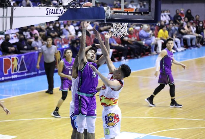 Converge FiberXers’ Justin Arana still managed to put up a shot despite being clobbered by the defense of two Rain or Shine Elasto Painters. PBA MEDIA BUREAU