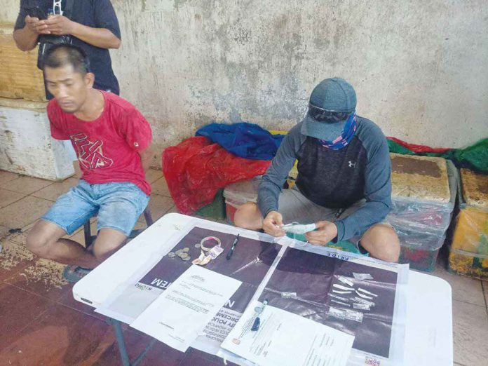 Silay City police arrested fish vendor Renato Espinosa (left) in a drug-buy-bust operation at the Silay public market on Dec. 6. RADYO BANDERA SWEET FM VICTORIAS CITY PHOTO