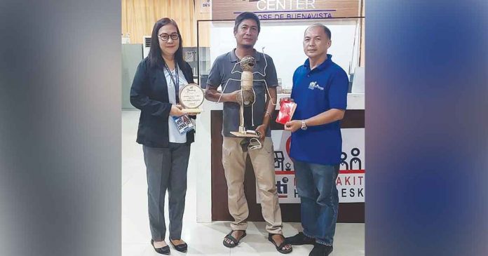 Coco craft maker Jeeff De Asis (center) holds his "hantic" or red ant coconut lampshade that won the Most Innovative Product during the Department of Trade and Industry (DTI) Antique's Panublion Heritage Fair in Iloilo City on Nov. 20, 2022. Also in the photo are DTI acting provincial director Lynna Joy Cardinal and Trade and Industry Development Specialist Wilson Alian. DTI ANTIQUE PHOTO