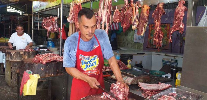 Pok vendor Ernesto Gulaylay, who has a stall at the public market of Pavia, Iloilo, notices a decrease in sales since the province recorded cases of African Swine Fever. AJ PALCULLO/PN