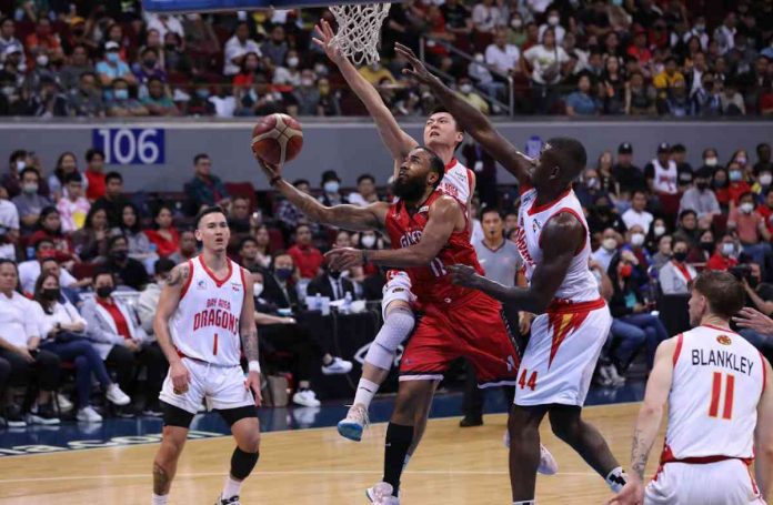 Barangay Ginebra San Miguel Kings’ Stanley Pringle goes for a tough reverse basket after being clobbered by the defense of Bay Area Dragons’ Zhu Songwei and Andrew Nicholson. PBA PHOTO