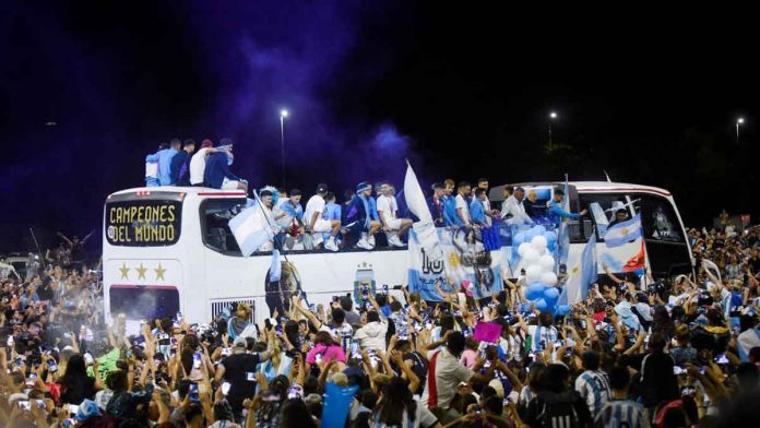 The Argentina football team on a bus in Buenos Aires on Dec. 20, 2022 surrounded by cheering fans. REUTERS